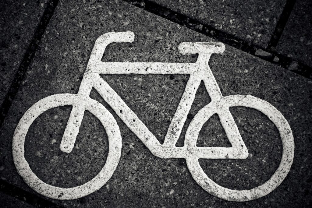 outline of a bike painted in white on black tarmac road surface